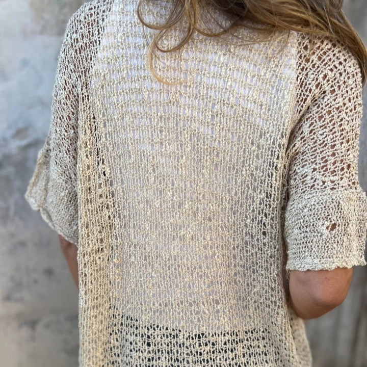 Hania - ニットのトップスにボタンが1つ付いています。